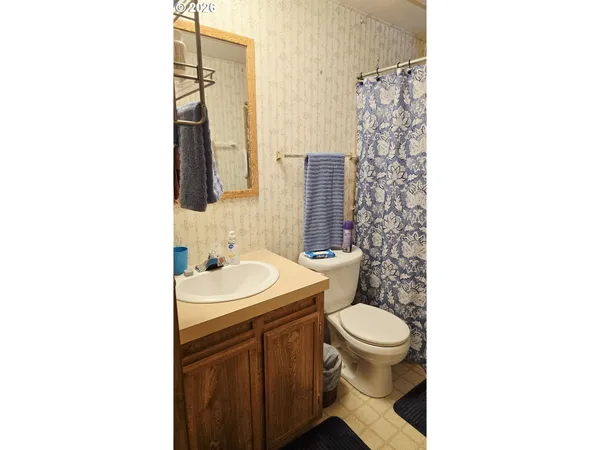 a bathroom with a sink a toilet and shower curtain