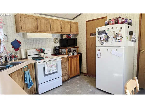 a kitchen with stainless steel appliances a stove a refrigerator a sink a cabinets and a dining table