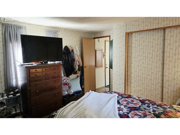 a bedroom with a bed and a flat screen tv