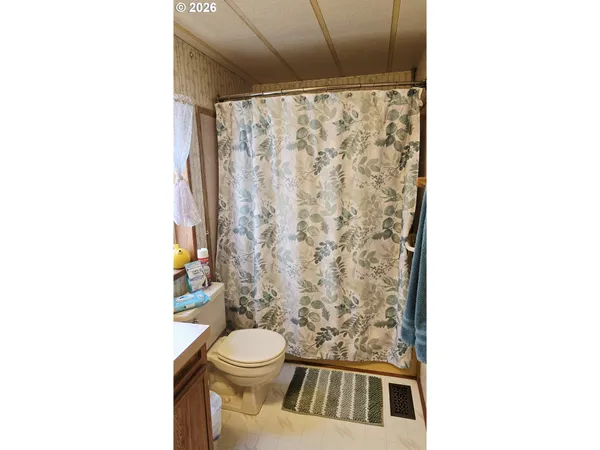 a bathroom with a toilet and a shower curtain