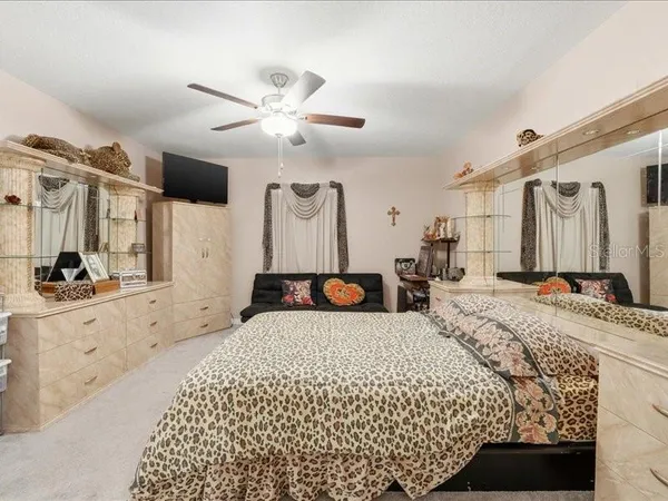 a large bedroom with a large bed and a chandelier