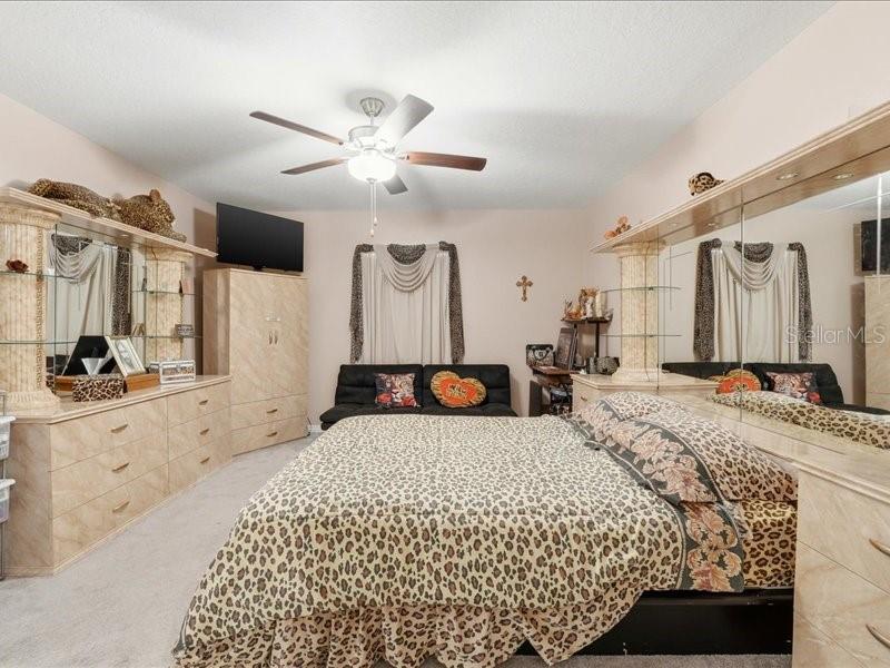 3943 Resting Robin Avenue Bartow, FL 33830 - Photo 14 of 38 a large bedroom with a large bed and a chandelier