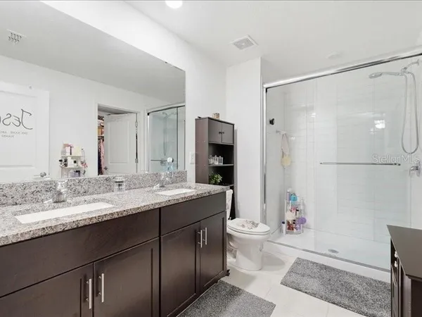 a bathroom with a granite countertop sink toilet and shower