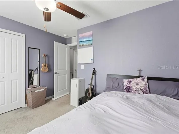 a bedroom with a large bed and a chandelier