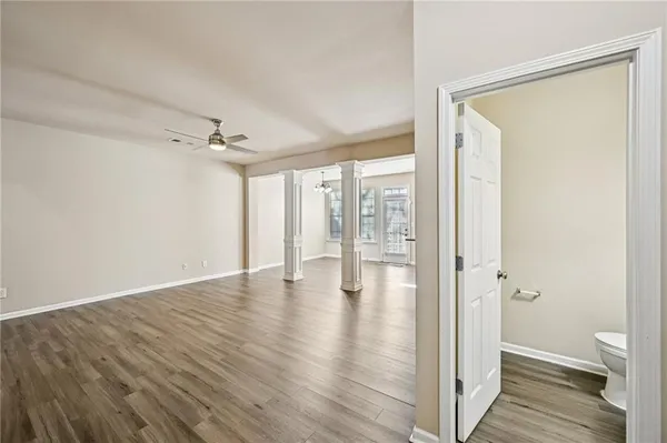 a view of an empty room and a bathroom with a glass door
