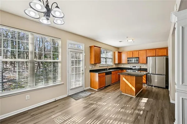 a view of a kitchen with stainless steel appliances granite countertop a stove and a wooden floors