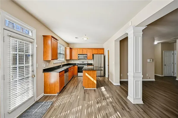 a large kitchen with stainless steel appliances granite countertop a stove and a wooden floors