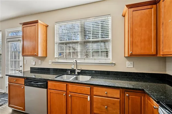 a kitchen with stainless steel appliances granite countertop a sink a stove and a granite counter tops with wooden floors