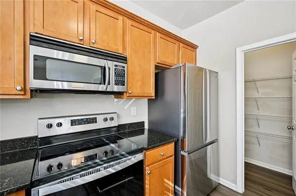 a kitchen with stainless steel appliances granite countertop a refrigerator stove and microwave
