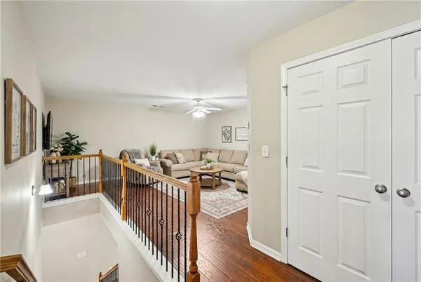a view of a hallway with wooden floor and furniture