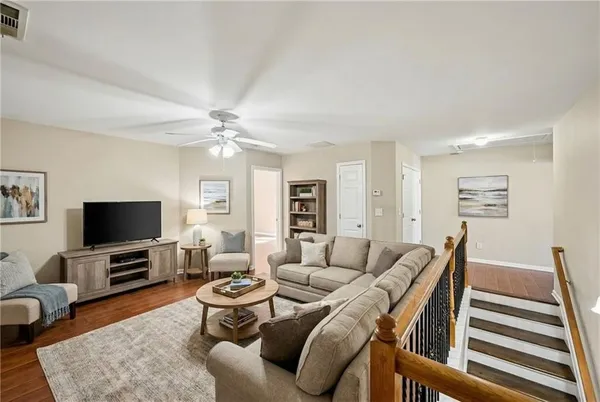 a living room with furniture a flat screen tv and kitchen view