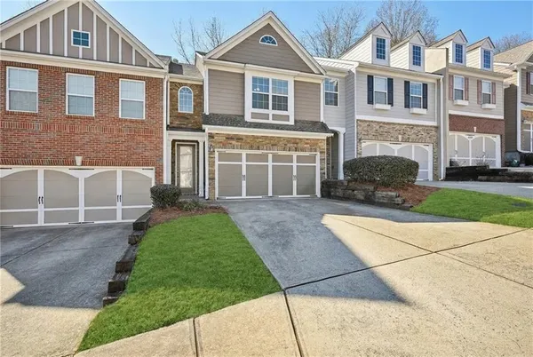 a front view of a house with a yard and a garage