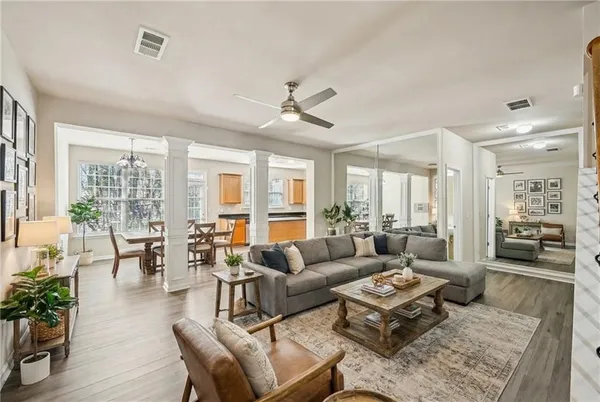 a living room with furniture potted plant and a large window