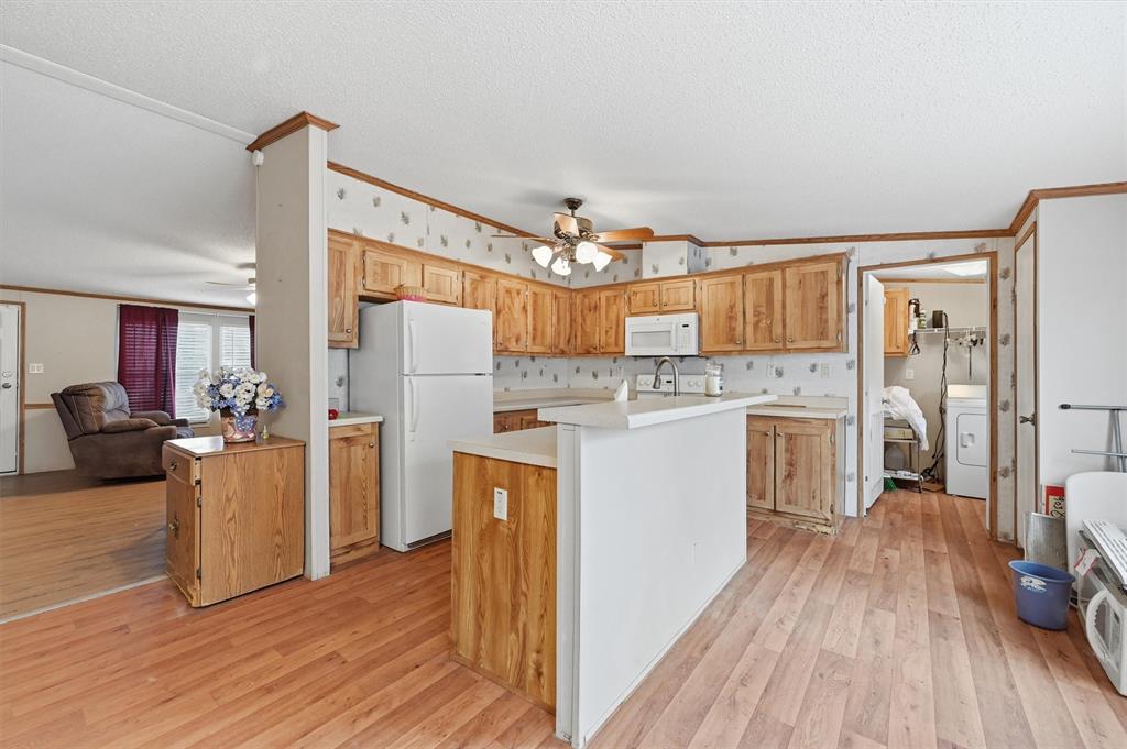 227 Sheryl Lane Denison, TX 75021 - Photo 14 of 37 a kitchen with a refrigerator a stove top oven a sink and cabinets with wooden floor