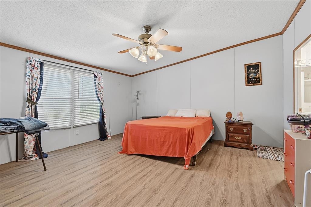 227 Sheryl Lane Denison, TX 75021 - Photo 17 of 37 a bed room with a bed and a chandelier