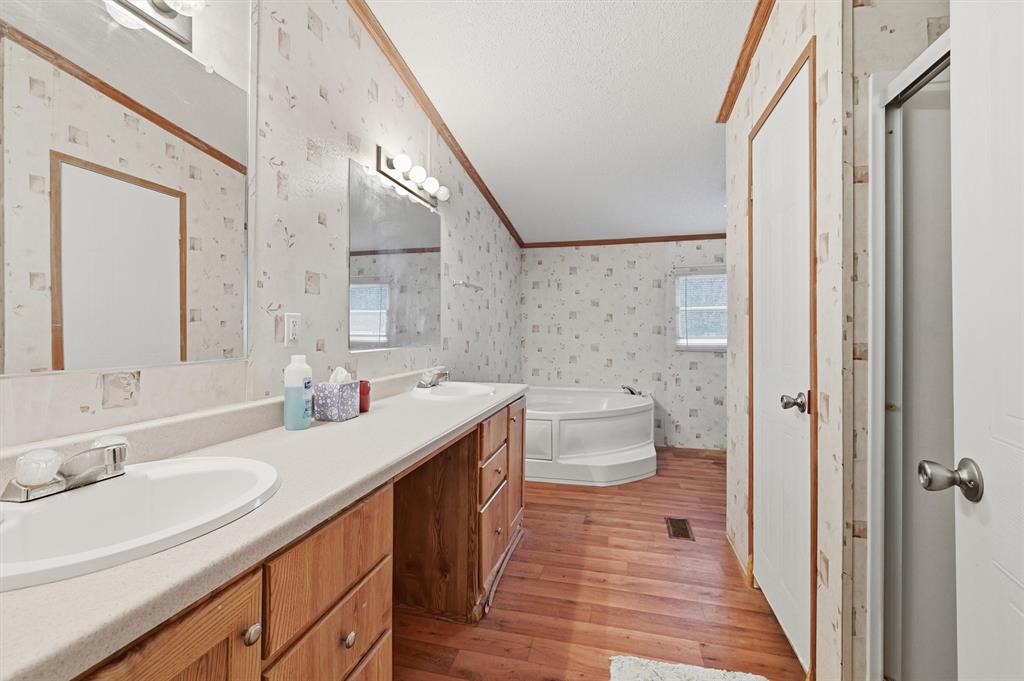 227 Sheryl Lane Denison, TX 75021 - Photo 18 of 37 a spacious bathroom with a double vanity sink toilet and a mirror
