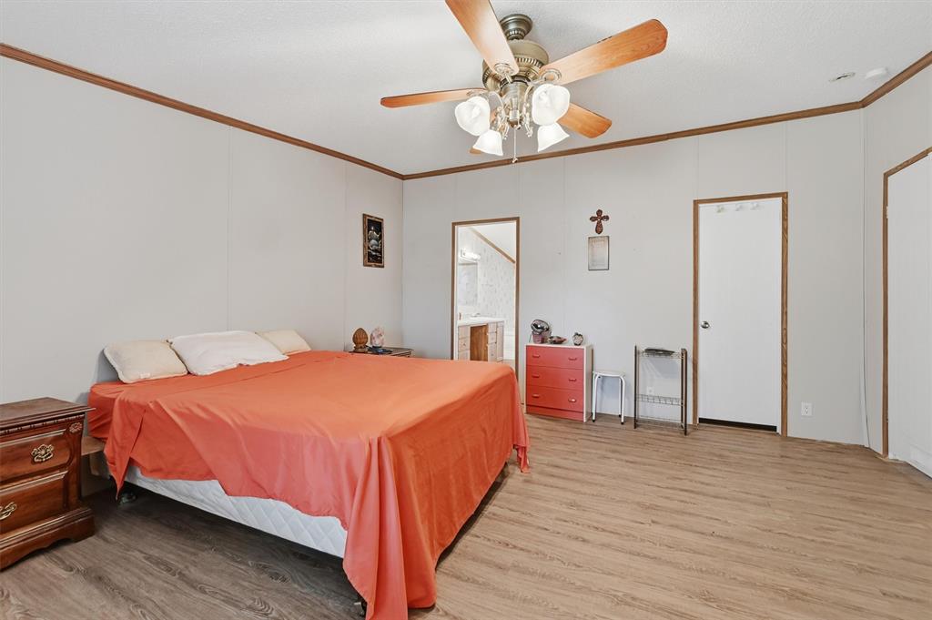 227 Sheryl Lane Denison, TX 75021 - Photo 18 of 37 a bedroom with a bed and a chandelier