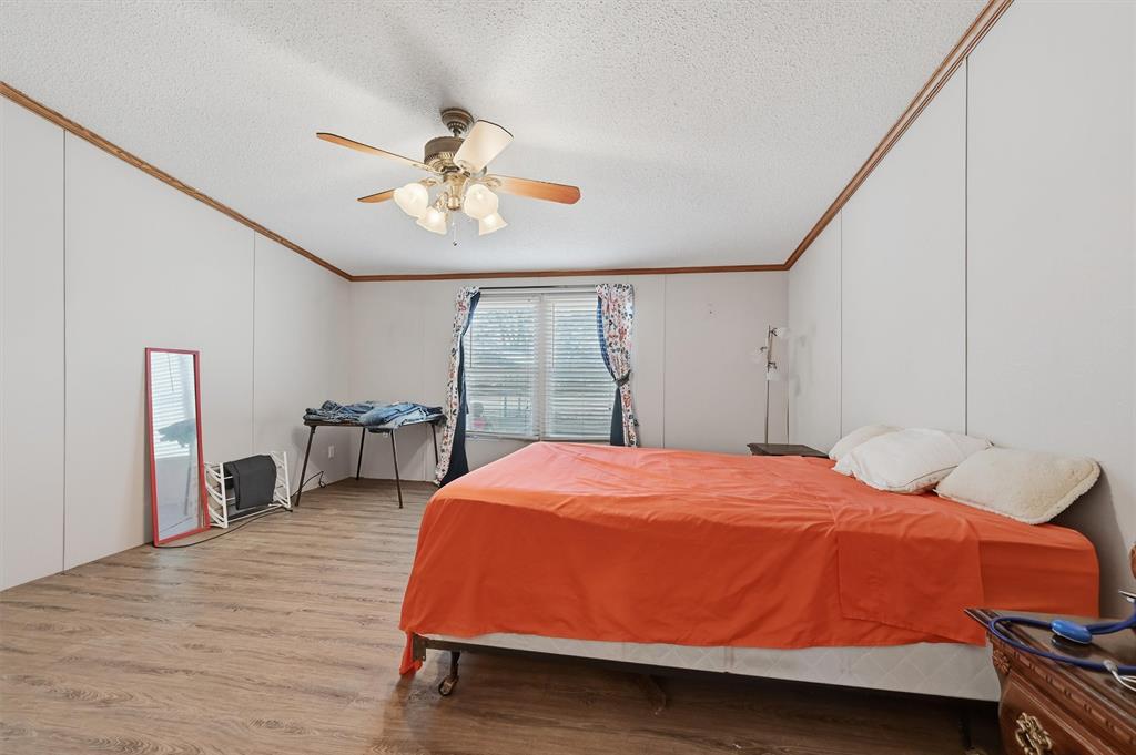 227 Sheryl Lane Denison, TX 75021 - Photo 19 of 37 a bedroom with a bed and a chandelier