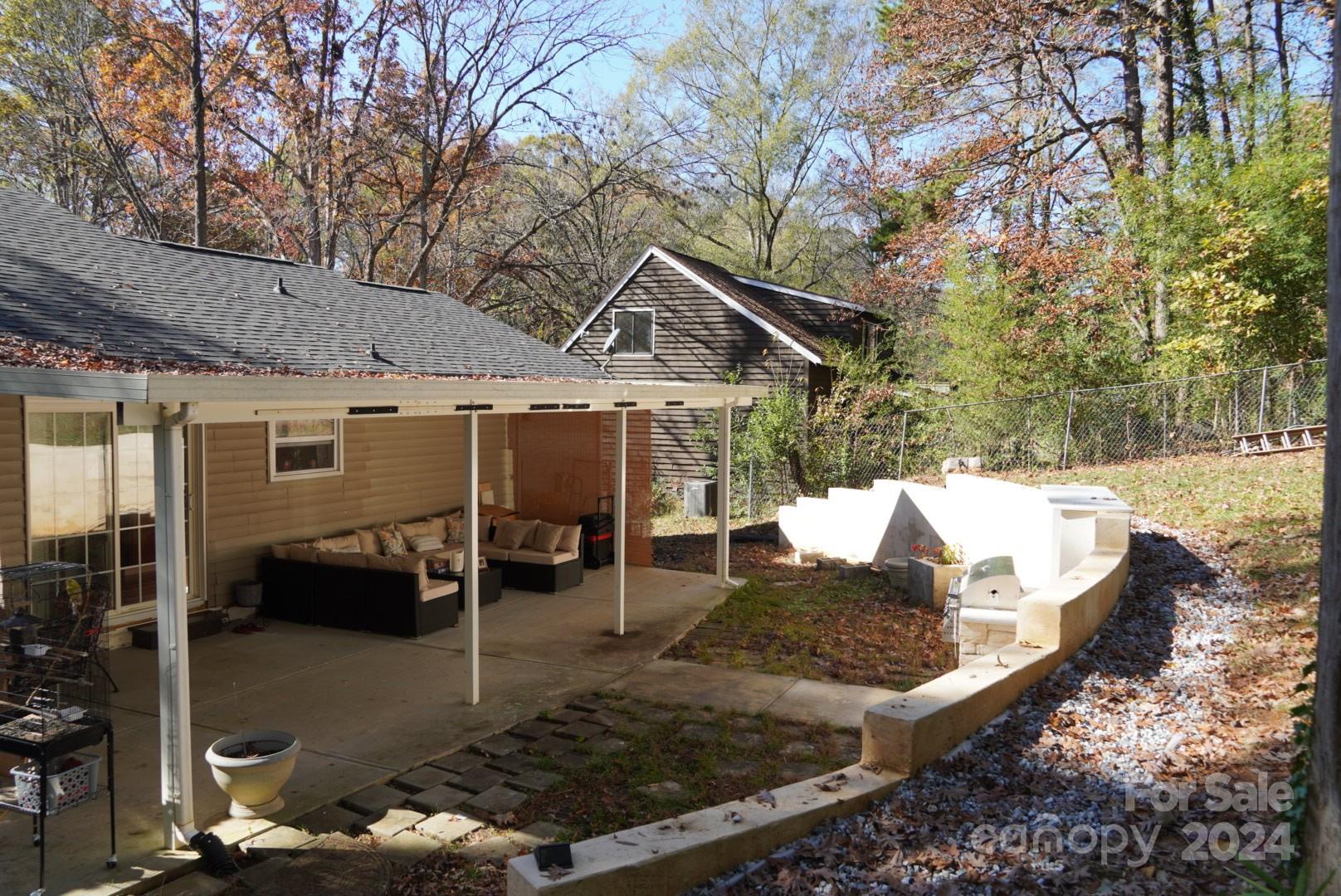 8357 Barncliff Road Charlotte, NC 28227 - Photo 12 of 15 a view of a patio with table and chairs with wooden fence and floor