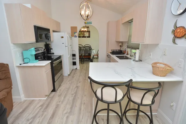 a kitchen with stainless steel appliances a table chairs and a refrigerator