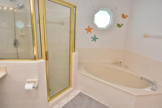 a bathroom with a tub a sink and a mirror