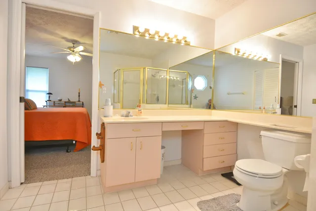 a spacious bathroom with a double vanity sink a mirror a toilet and a shower