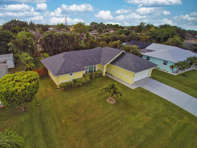 an aerial view of residential houses with outdoor space and trees