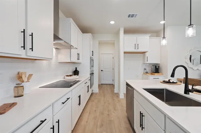 a kitchen with cabinets a sink and appliances