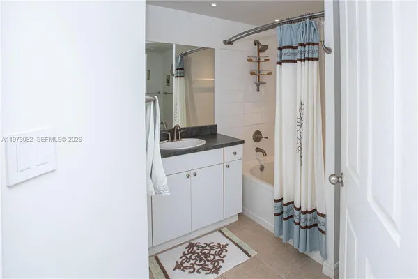 a bathroom with a granite countertop sink a mirror a vanity and a shower