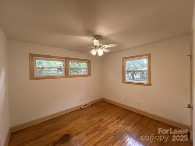 a view of a room that has a window and wooden floor