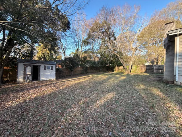 a view of a house with a yard and a tree