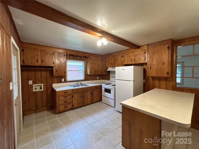 a kitchen with a refrigerator a stove top oven and a sink