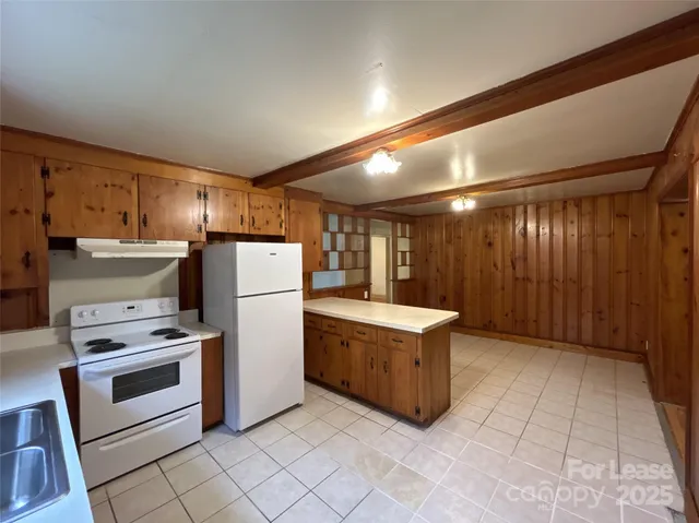 a kitchen with refrigerator and cabinets