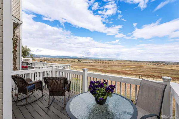 a view of a balcony with furniture and wooden floor