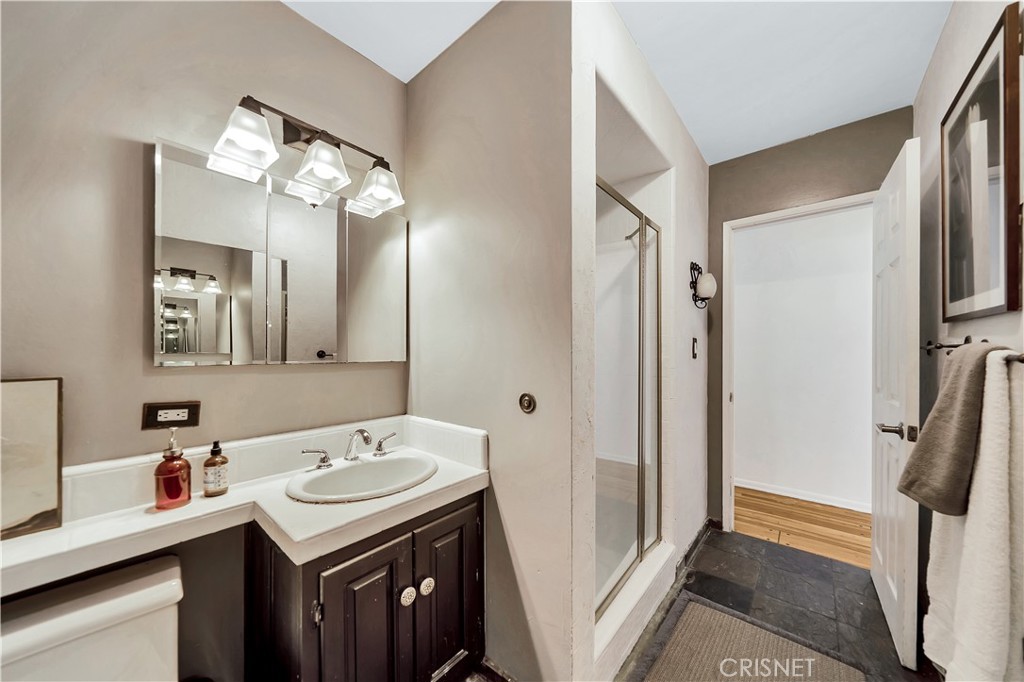 3667 Willowcrest Avenue Studio City, CA 91604 - Photo 19 of 49 a bathroom with a sink a toilet a mirror and shower view