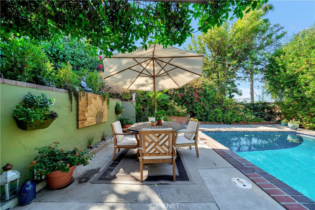 3667 Willowcrest Avenue Studio City, CA 91604 - Photo 37 of 49 a backyard of a house with table and chairs under an umbrella