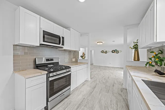 a kitchen with stainless steel appliances a stove microwave and cabinets
