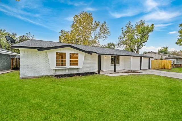 a view of a house with a yard and a patio