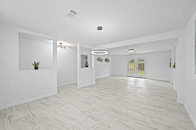 a view of empty room with wooden floor and window