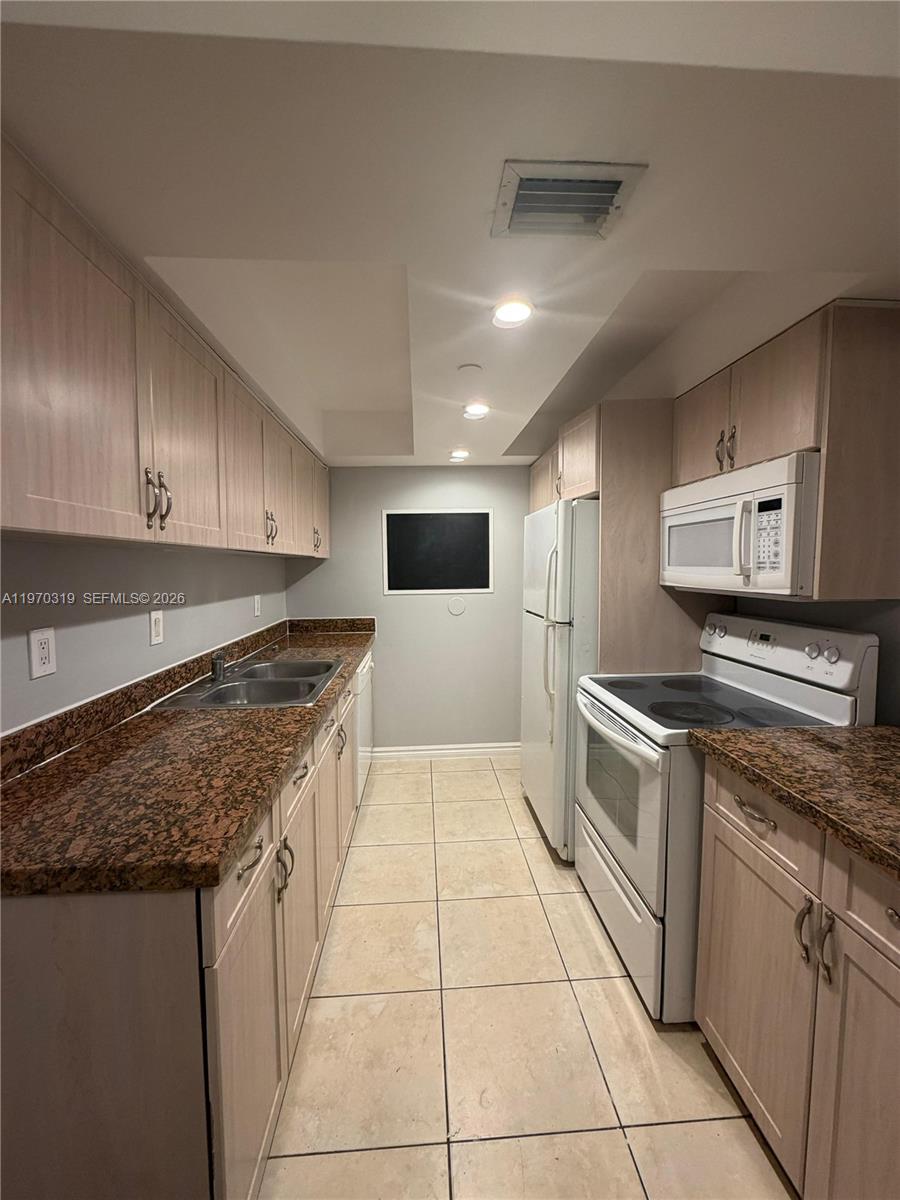 17600 North Bay Road, Unit N907 Sunny Isles Beach, FL 33160 - Photo 1 of 22 a large kitchen with stainless steel appliances granite countertop a stove a sink and a refrigerator