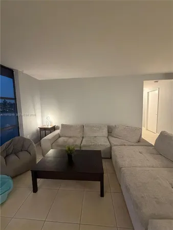 a living room with furniture and a lamp
