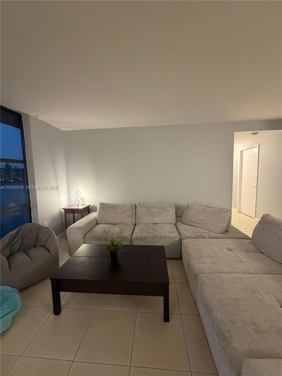 17600 North Bay Road, Unit N907 Sunny Isles Beach, FL 33160 - Photo 6 of 22 a living room with furniture and a lamp