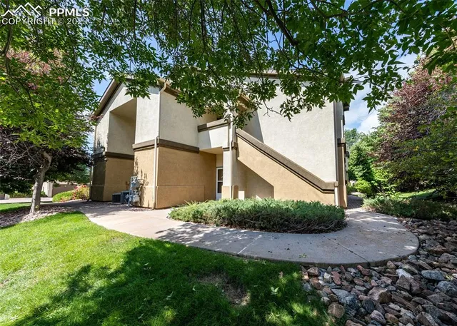 a view of a yard in front of a house with large tree