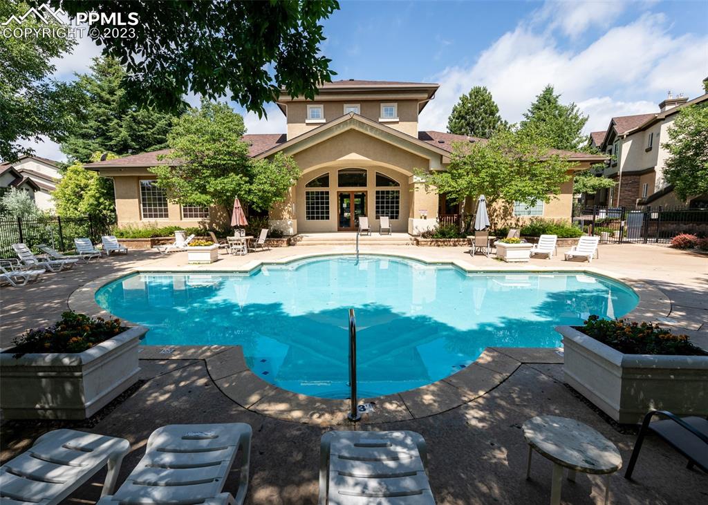 3847 Riviera Grove, Unit 203 Colorado Springs, CO 80922 - Photo 3 of 32 a front view of a house with swimming pool garden and patio