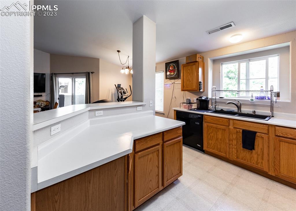 3847 Riviera Grove, Unit 203 Colorado Springs, CO 80922 - Photo 9 of 32 a kitchen with a sink stove and cabinets