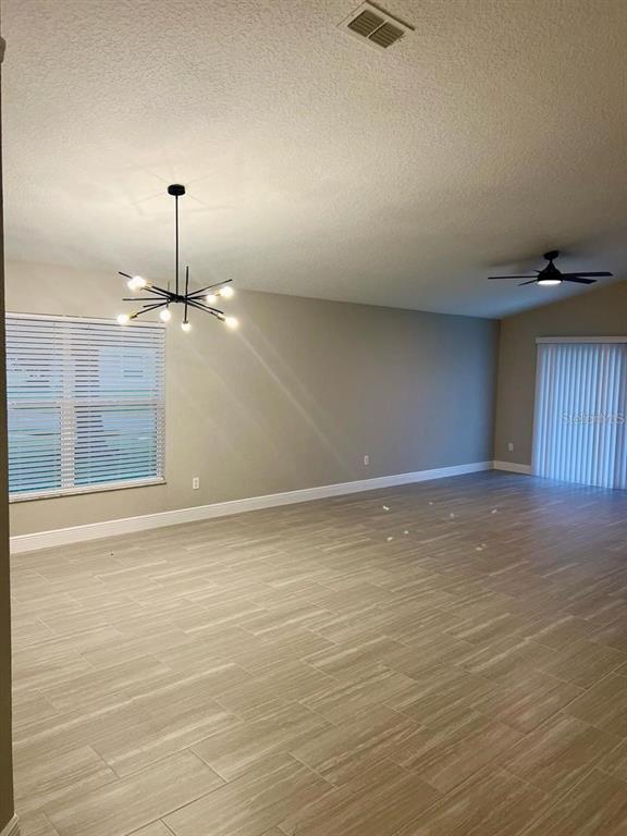 2917 Conner Lane Kissimmee, FL 34741 - Photo 2 of 10 an empty room with wooden floor fan and window