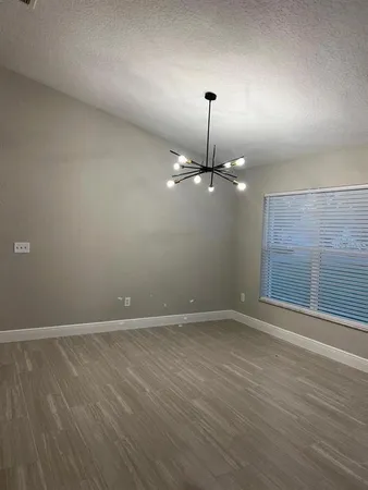 an empty room with wooden floor and fireplace