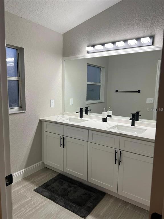 2917 Conner Lane Kissimmee, FL 34741 - Photo 5 of 10 a bathroom with a double vanity sink and mirror