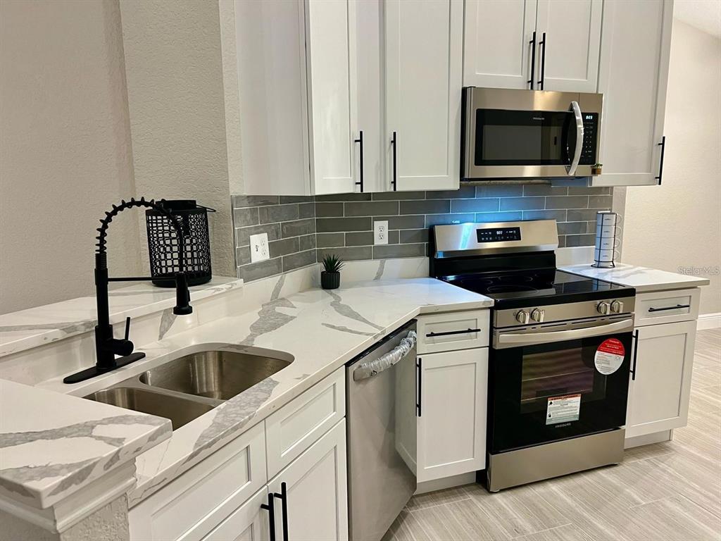 2917 Conner Lane Kissimmee, FL 34741 - Photo 10 of 10 a kitchen with stainless steel appliances granite countertop a sink and a stove
