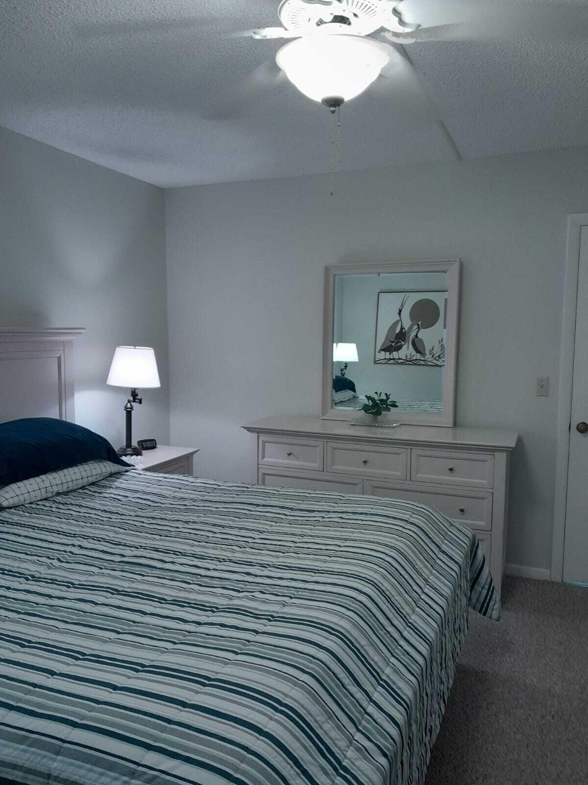 1605 Highway 1, Unit C302 Jupiter, FL 33477 - Photo 19 of 30 a bedroom with a bed and a chandelier